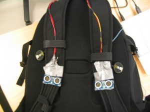 Integration: two PING))) sensors attached on top of the shoulder-strap and two C-2 actuators that are attached under the straps.